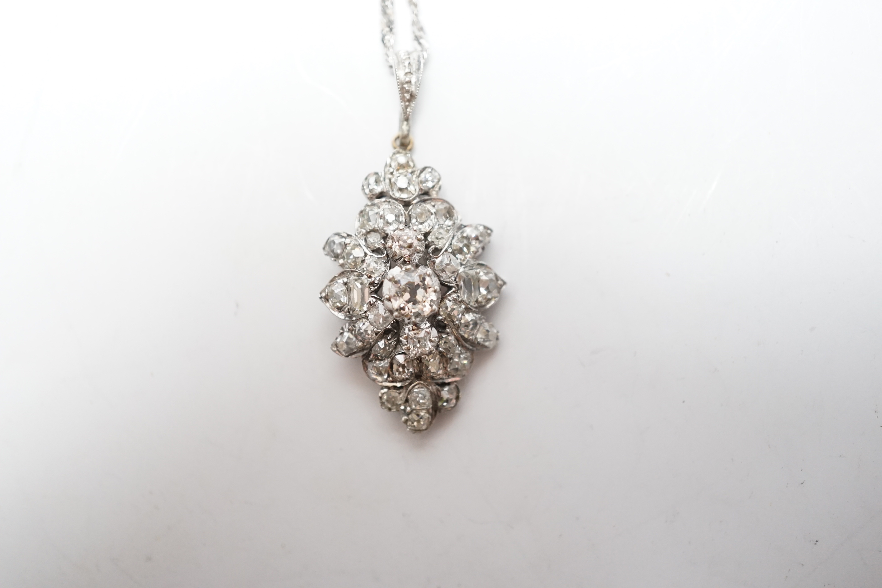 A white metal and diamond cluster set lozenge shape pendant, overall 38mm, on a modern 9ct white gold, chain, 45cm, gross weight 5.8 grams.